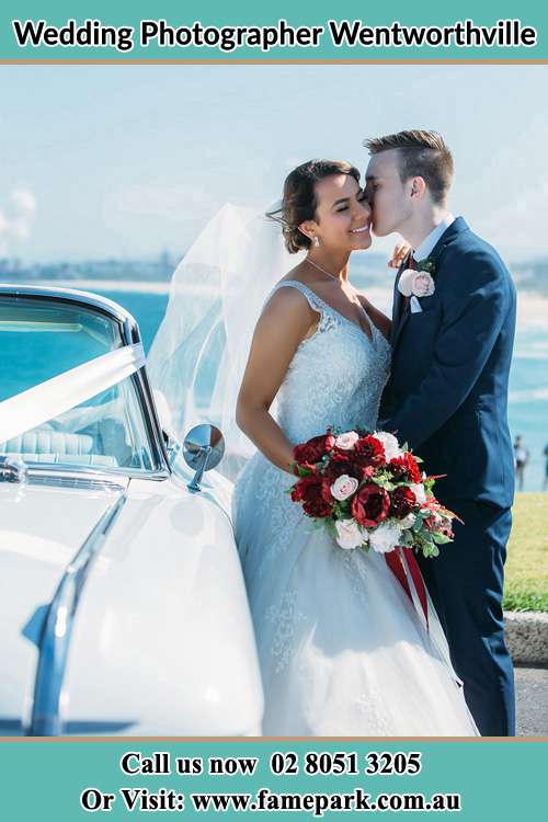 Photo of the Groom kiss the Bride besides the bridal car Wentworthville NSW 2145